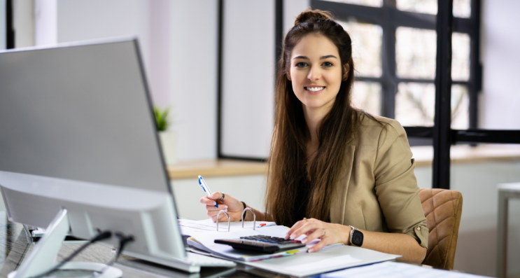 Moça jovem sentada em frente ao notebook iniciando a carreira em contabilidade