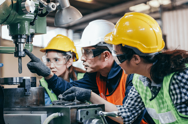 Funcionários em indústria interagindo de forma colaborativa, representando um ambiente de trabalho positivo