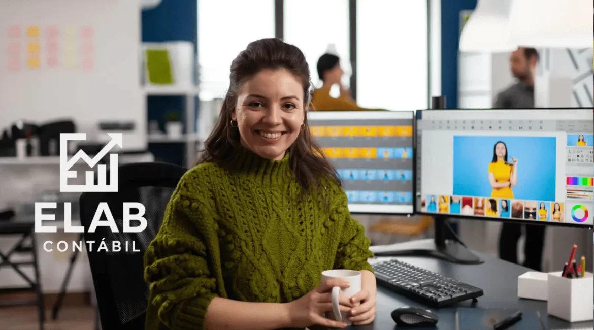 Mulher feliz tomando café enquanto trabalha no computador, representando MEI que pode contratar funcionário