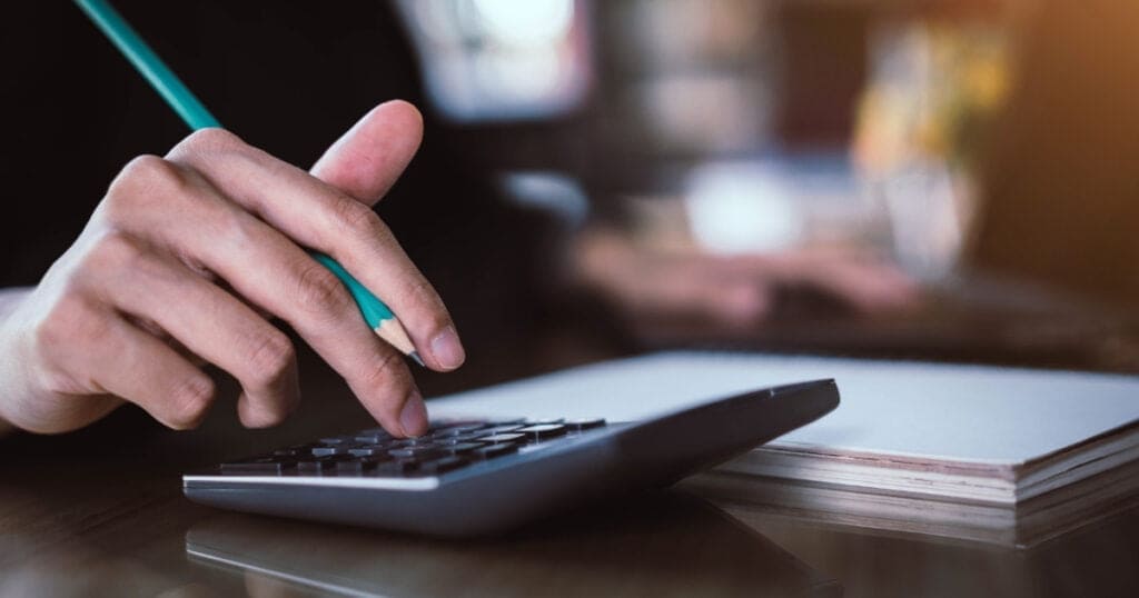 Materiais de escritório e calculadora representando o conceito de despesas fixas