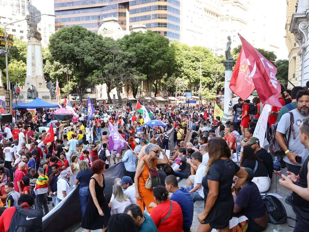Manifestação trabalhista com pessoas reunidas segurando cartazes