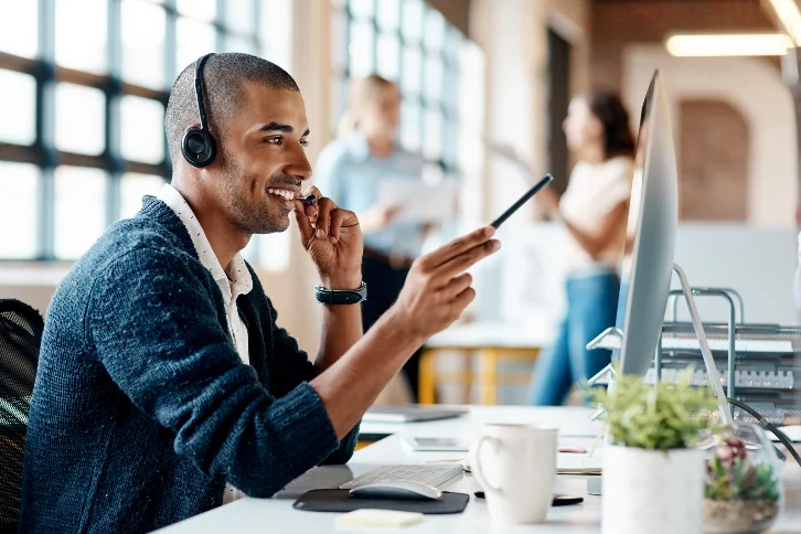 Homem com fone de ouvido realizando atendimento rápido ao cliente por telefone, representando agilidade e suporte eficiente