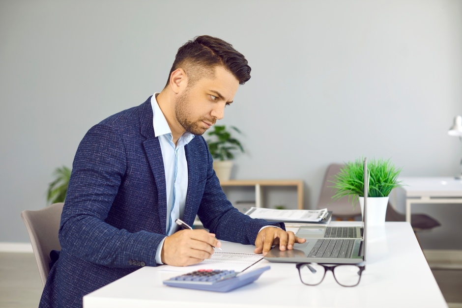 Honorários contábeis de empresas sendo calculados, com planilhas, documentos e calculadora