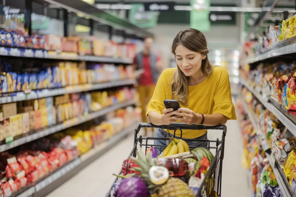 Mulher realizando compras no supermercado de forma organizada