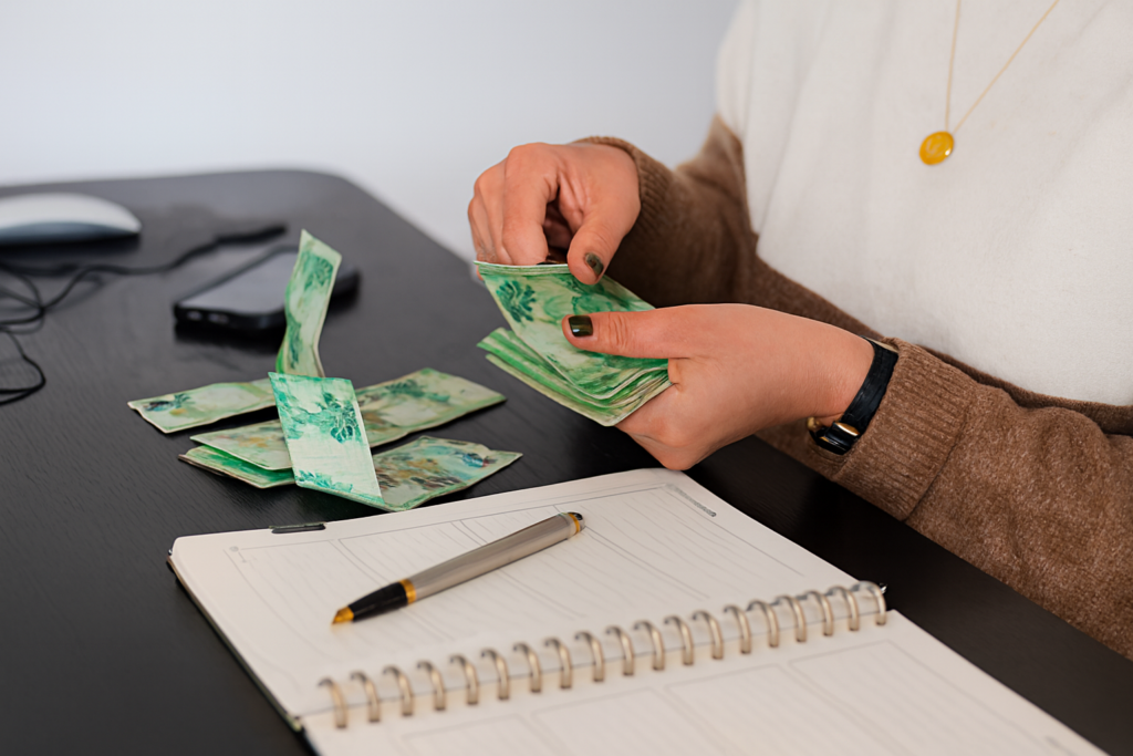 Pessoa organizando contas e efetuando pagamentos com dinheiro em reais.