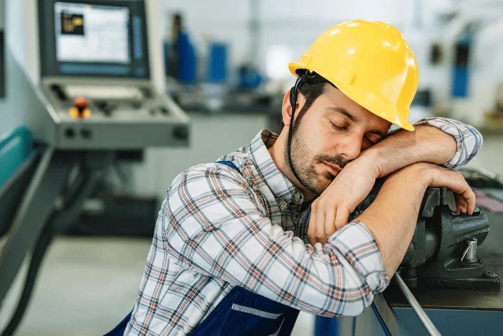 Trabalhador adormecido em sua mesa durante o expediente.