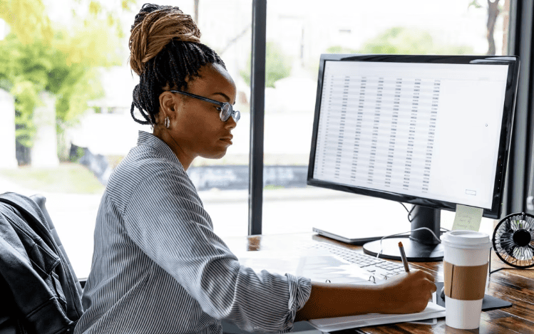 Nanoempreendedora trabalhando durante a Reforma Tributária, representando adaptação às novas regras fiscais