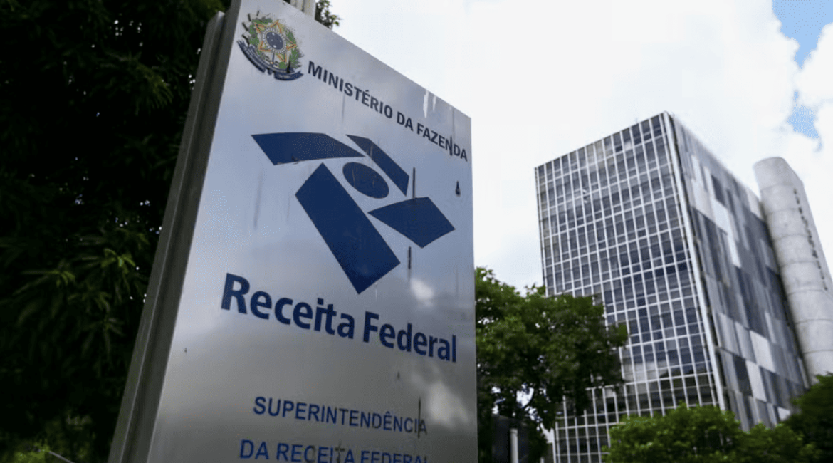 Analista avaliando documentos e relatórios fiscais de uma empresa.