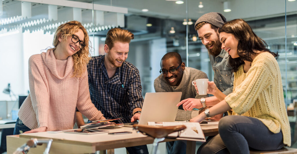 Pessoas trabalhando em equipe no ambiente corporativo, colaborando em tarefas profissionais